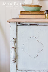 White Parlour Milk Paint cabinet by Homestead House with decorative handle, books, and decor on top.