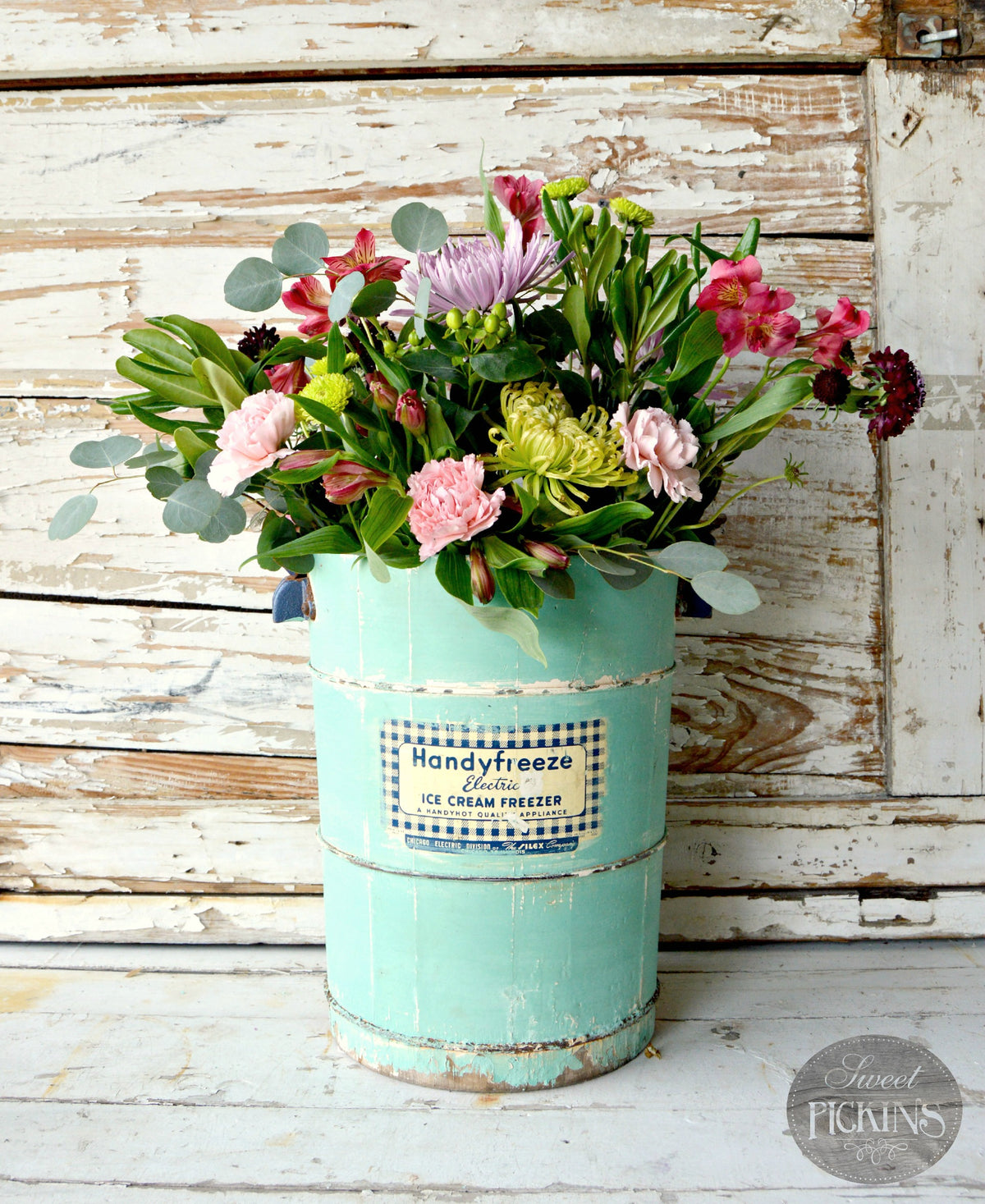 Assorted flowers in a Patina-painted vintage bucket by Old Fashioned Milk Paint.