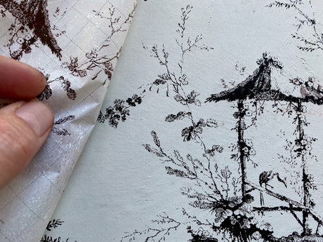 Hand peeling wallpaper to reveal black ink gazebo design with I.O.D. Petits Parasols Black Paint Inlay.