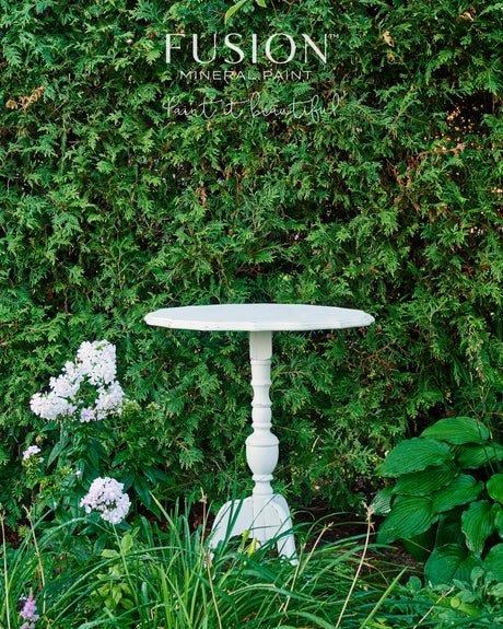 Pure white round table finished in Picket Fence Fusion Mineral Paint by Fusion Mineral Paint, shown outdoors.