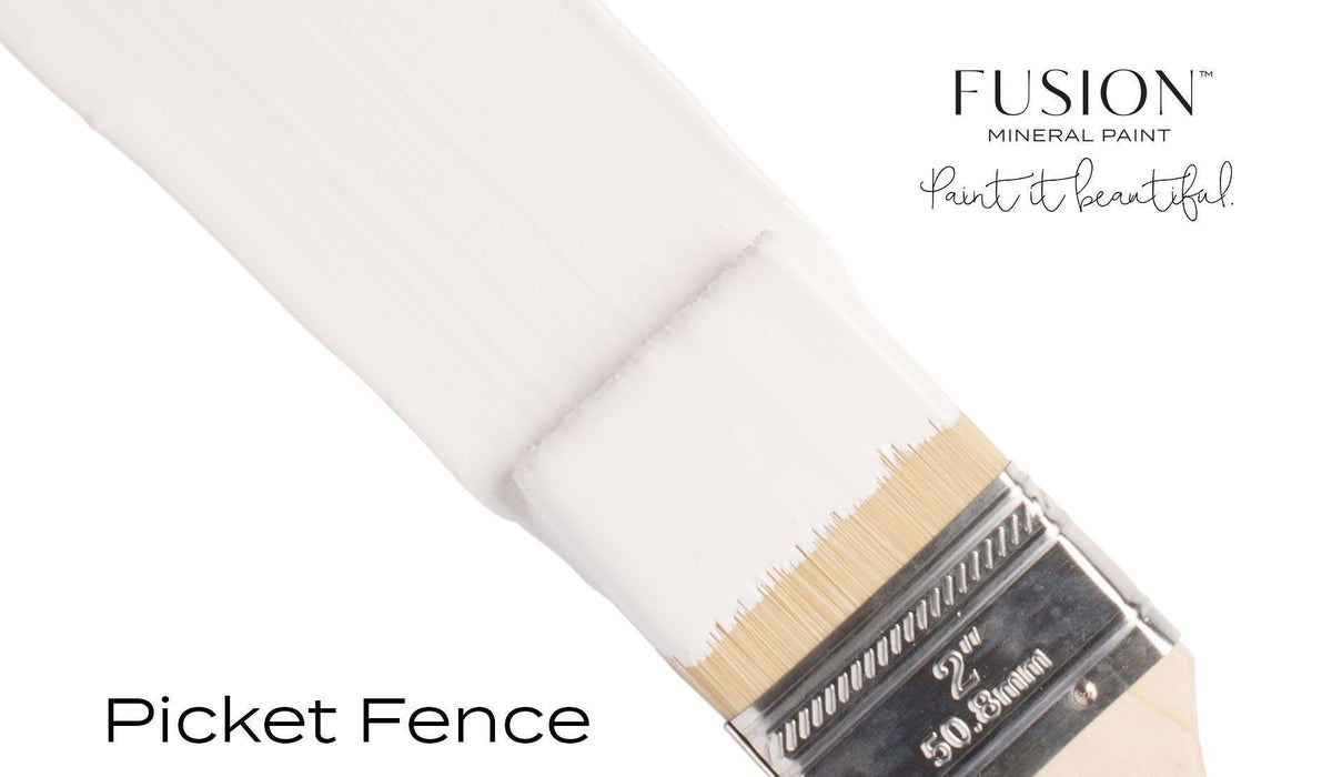 Brush with white Picket Fence Fusion Mineral Paint on bristles, shown with branding on a white background.