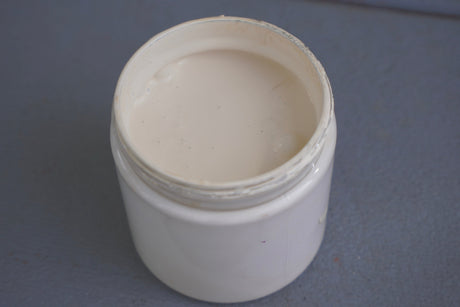 Open jar of Plaster DIY Cottage Color by DIY Paint Co. showing creamy off-white paint inside.