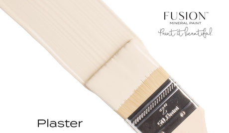 Paintbrush with off-white Plaster Fusion Mineral Paint; Fusion Mineral Paint logo and slogan in the corner.