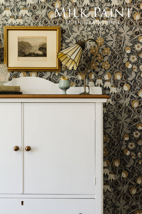 White cabinet finished in Homestead House Porcelain Milk Paint, shown with a lamp and picture on top.