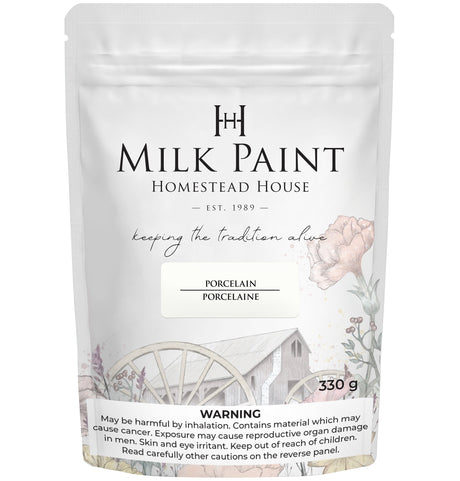 Homestead House Porcelain Milk Paint 330g bag with floral art, wagon wheel graphic, and warning label.