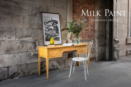 Yellow desk painted in Prairie Sunset Milk Paint by Homestead House, paired with white chair and books; product name above.