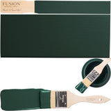Brush with green paint next to a swatch and open Fusion Mineral Paint Pressed Fern container.