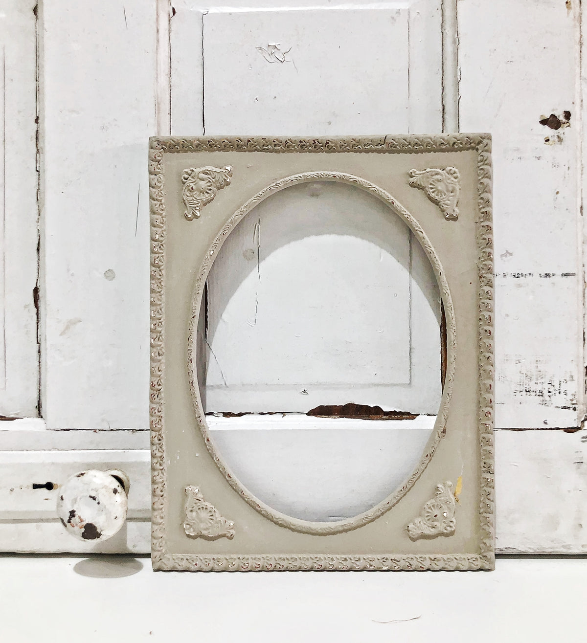 Ornate oval frame against white wood wall painted with Proper by Old Fashioned Milk Paint, VOC free.