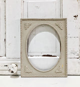 Ornate oval frame against white wood wall painted with Proper by Old Fashioned Milk Paint, VOC free.