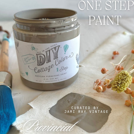 Open jar of Provincial DIY Cottage Color by DIY Paint Co., with brush, dried flowers, and painted swatch nearby.
