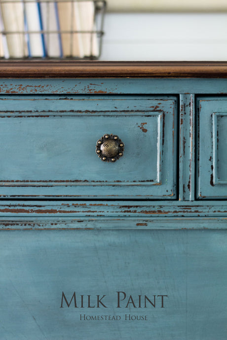 Distressed Quaker Blue Milk Paint drawer with round knob; text reads “Quaker Blue Milk Paint Homestead House.”.
