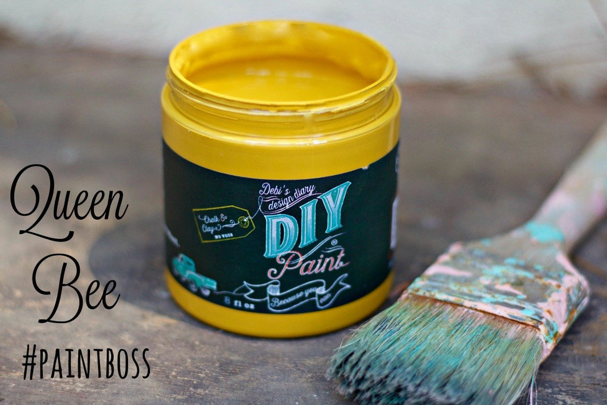 Open jar of Queen Bee DIY Paint by DIY Paint Co. next to a brush with dried bristles.