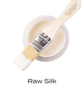 Paintbrush with all-in-one acrylic rests on open Fusion Mineral Paint Raw Silk jar.