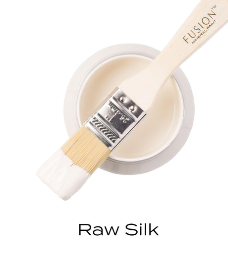 Paintbrush with all-in-one acrylic rests on open Fusion Mineral Paint Raw Silk jar.