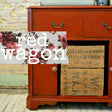 Red Wagon-painted sideboard by Old Fashioned Milk Paint with floral script and stacked crates in front.