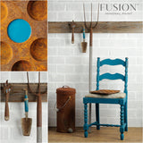 Chair painted in Renfrew Blue Fusion Mineral Paint beside garden tools and a can.