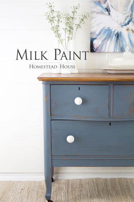 Blue dresser with white knobs and wooden top; Rideau Blue Milk Paint by Homestead House on walls.