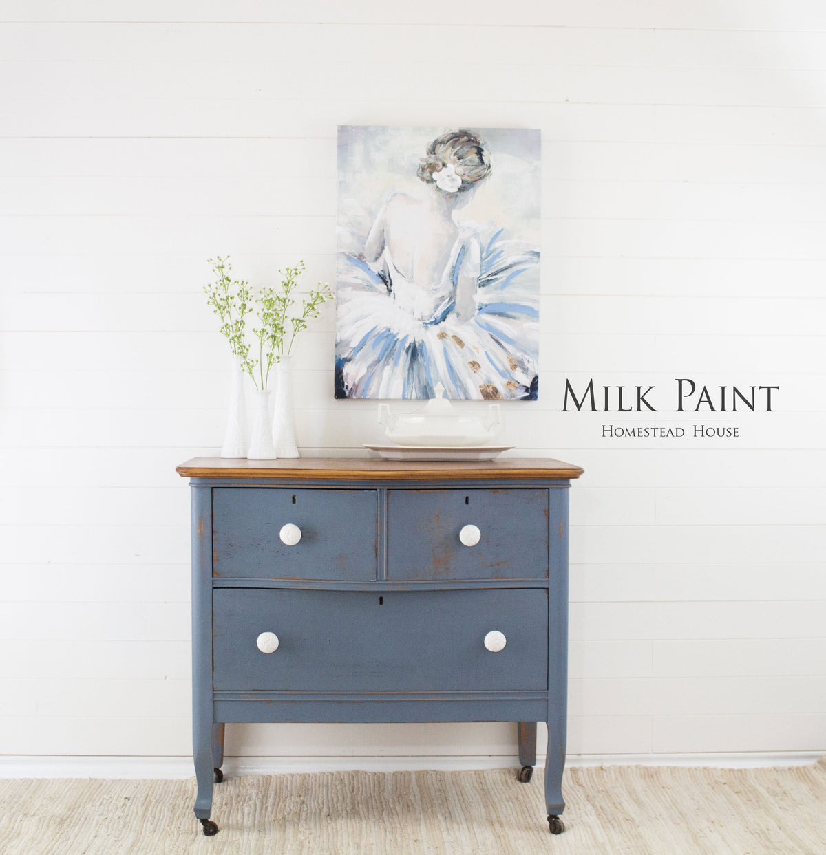 Blue dresser in Rideau Blue Milk Paint by Homestead House, with two white vases and a ballerina painting.