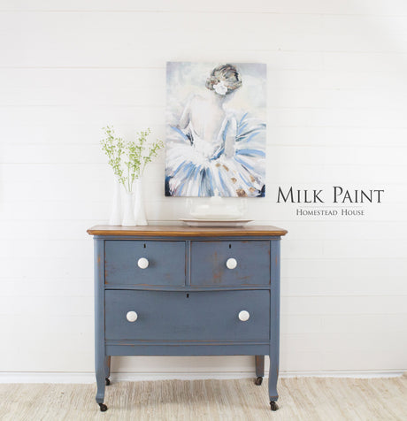 Blue dresser in Rideau Blue Milk Paint by Homestead House, with two white vases and a ballerina painting.