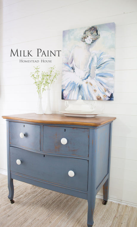 Dresser in Homestead House Rideau Blue Milk Paint with white knobs, topped with a vase and ballerina art.