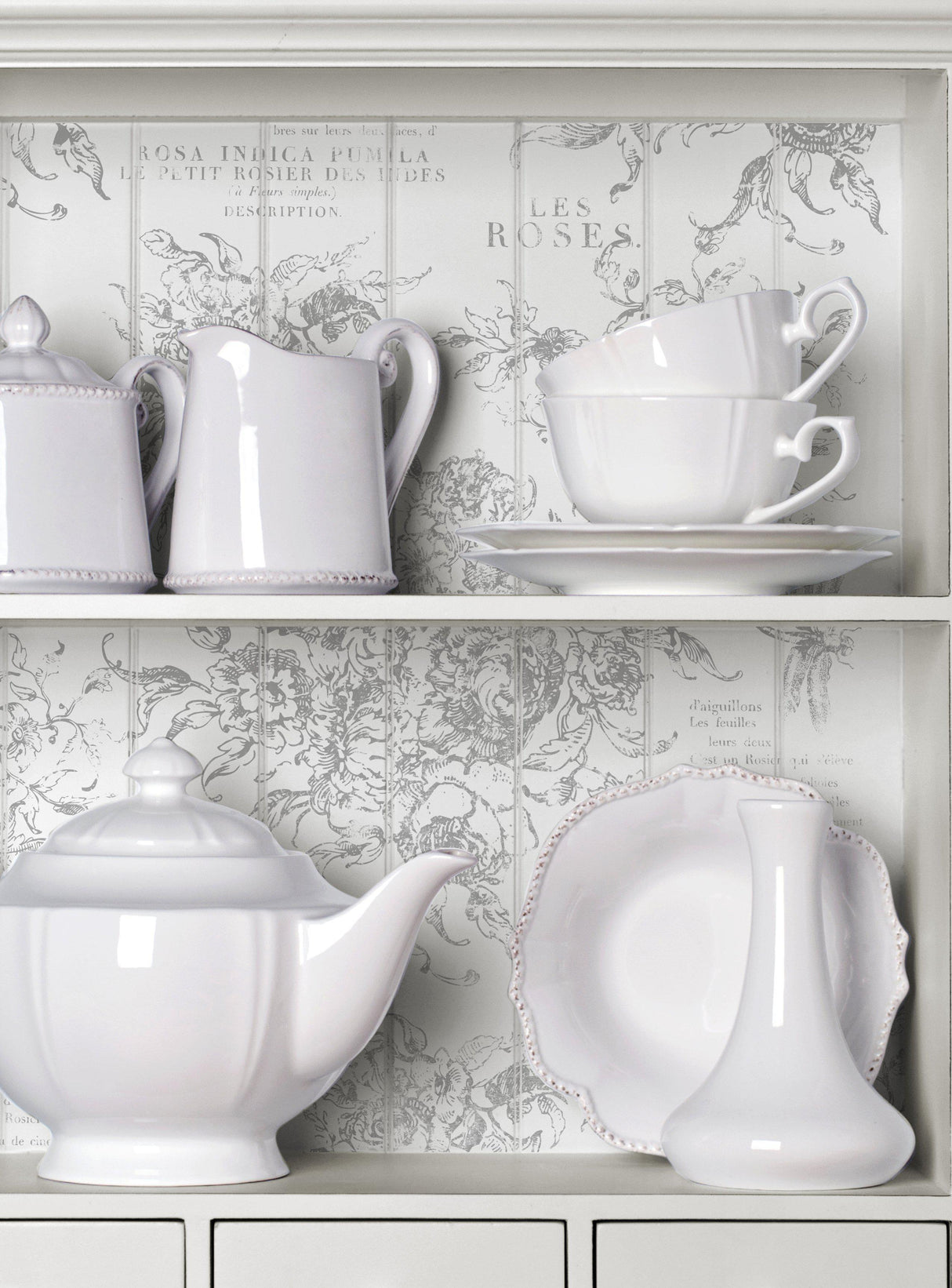 White ceramic dishes, teapot, and shelves decorated with I.O.D. Rose Toile Stamp.