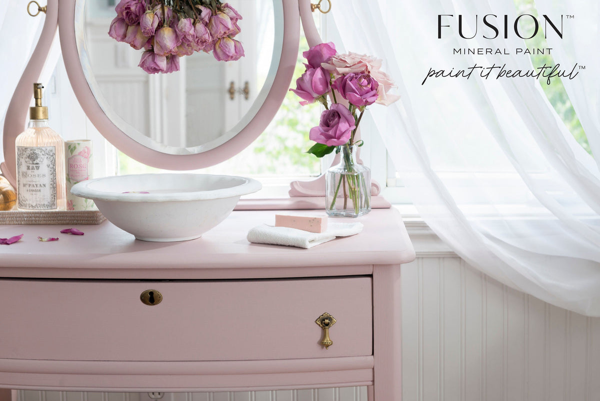 Neutral pink vanity with white bowl, soap, flowers, and sheer curtains in Rose Water by Fusion Mineral Paint.