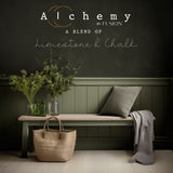 Bench with green vases, a pillow, and a straw bag against Rosemary by Fusion Mineral Paint wall.