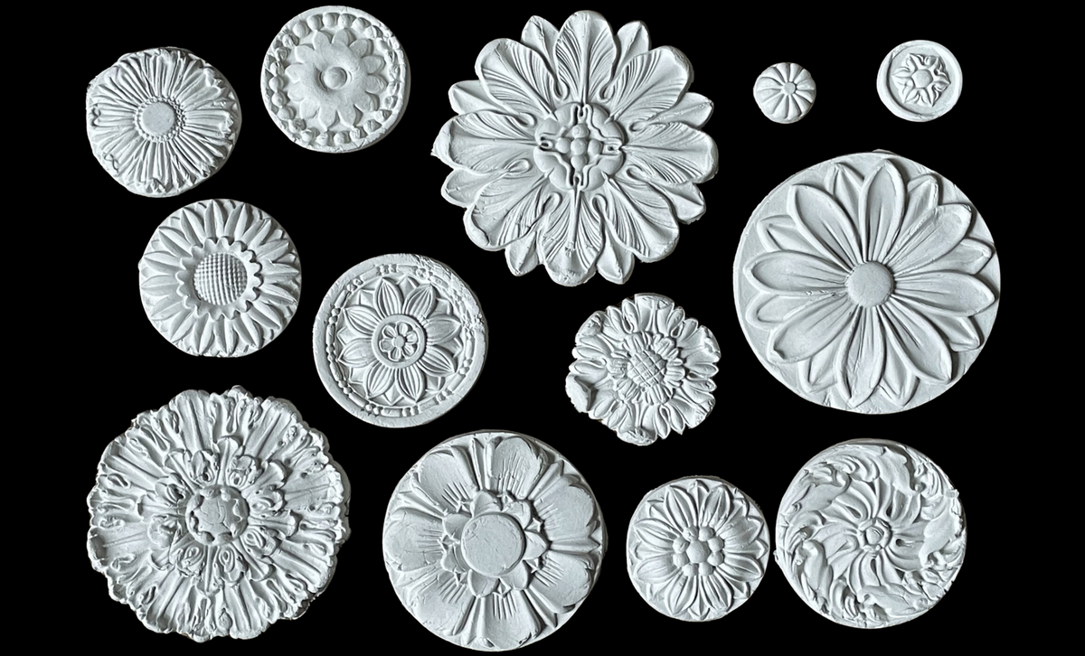 Fourteen white Rosettes Mould flowers by IOD displayed on a black background.