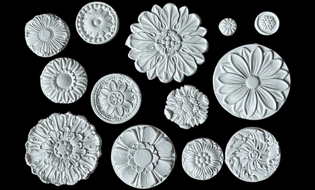 Fourteen white Rosettes Mould flowers by IOD displayed on a black background.