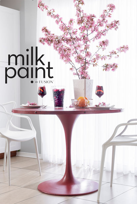 Round pink table painted in Fusion Mineral Paint Sangria, styled with wine glasses, fruit, and florals.