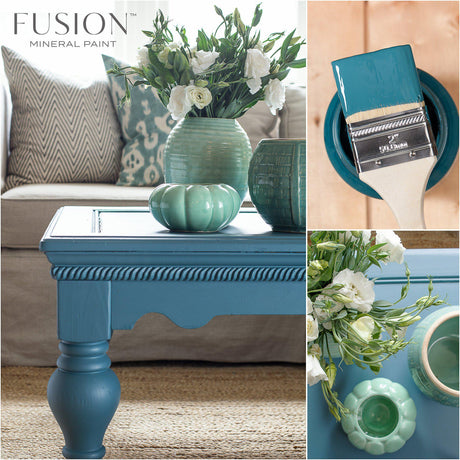 Table painted in Seaside by Fusion Mineral Paint with green vases, white flowers, and a teal-tipped paintbrush.