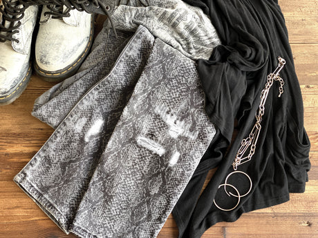 White boots, snake print jeans, black top, styled with I.O.D. Serpentine Stamp flair and silver accessories.