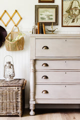 Wicker basket, lantern, and dresser painted in Homestead House Silhouette Milk Paint with books and wall art.