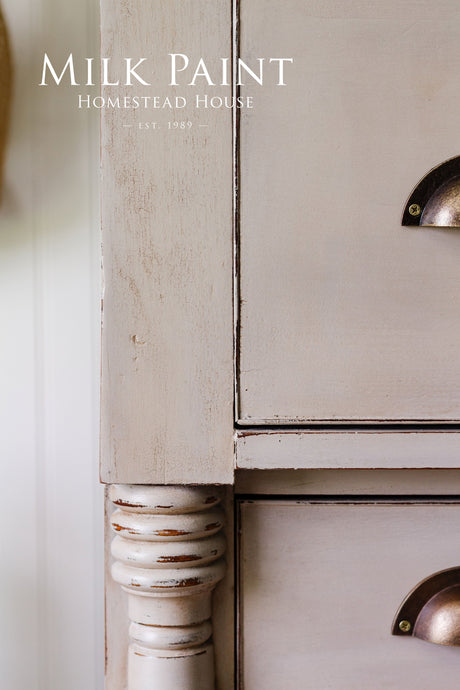 Distressed wood dresser with metal handles, finished in Silhouette Milk Paint by Homestead House.