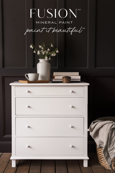 White dresser painted in Fusion Mineral Paint Snowdrop, styled with books, mug, and flowers.