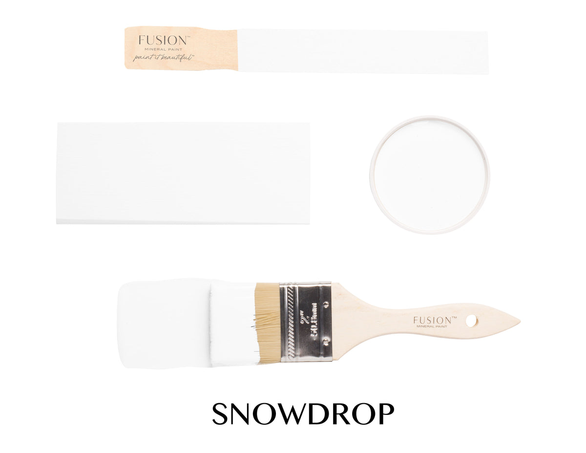 Fusion Mineral Paint Snowdrop sample, paintbrush, and jar lid arranged together on a white surface.