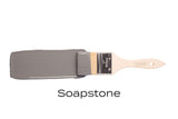 Paintbrush with Fusion Mineral Paint in Soap Stone (deep gray, matte) by Fusion on white background.