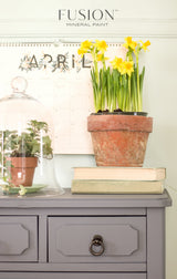 Potted daffodil and books on dresser painted in Soap Stone Fusion Mineral Paint.