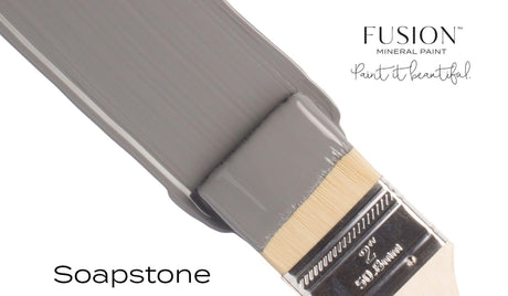 Fusion Mineral Paint brush in Soap Stone gray shade with product text in the background on white.