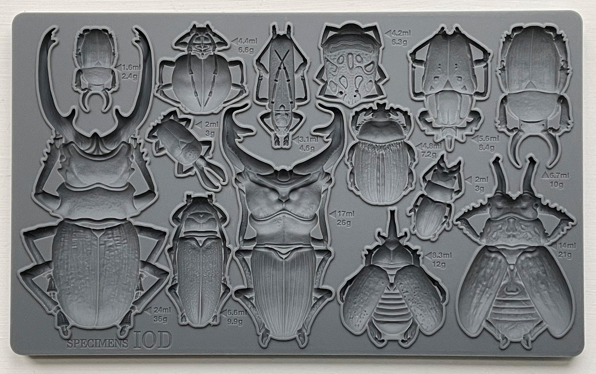 Specimens Mould by I.O.D., gray silicone tray with 17 beetle-shaped cavities labeled for weight and volume.