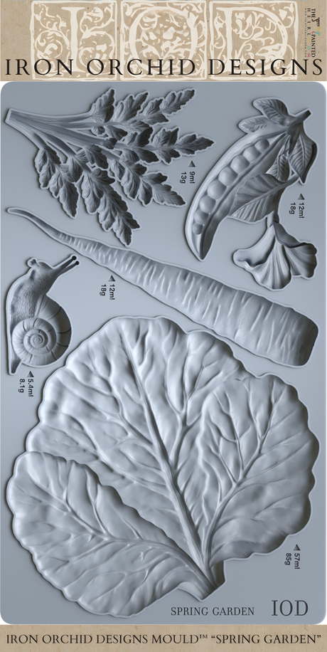 Spring Garden Mould by I.O.D. with embossed snail, carrot, pea, leaf, and cabbage leaf designs.