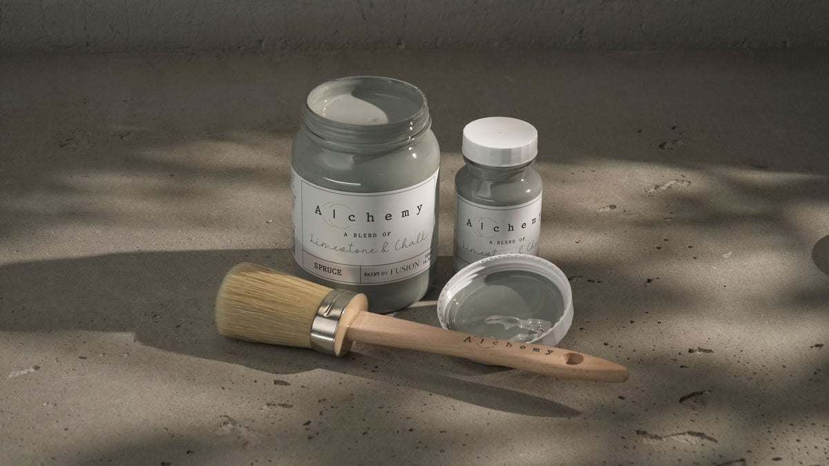 Three jars of Spruce Alchemy Paint by Fusion Mineral Paint with a paintbrush, one jar and brush open.