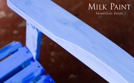 St-Laurent Blue Milk Paint by Homestead House on wooden chair arm; brand name shown in upper right corner.