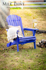 Blue Adirondack chair painted with Homestead House St-Laurent Blue Milk Paint, shown with wine and a blanket.