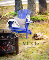 Blue chair painted with Homestead House St-Laurent Blue Milk Paint on grass near a firepit.