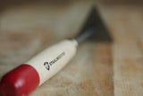 Staalmeester Scrapers & Strippers tool with red end displayed on a wooden surface.