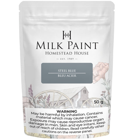 Homestead House Steel Blue Milk Paint 50g pouch with rustic design and health warning label visible.