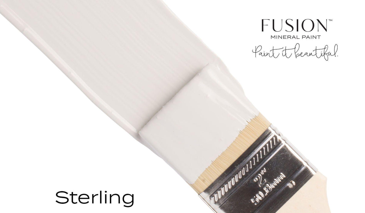 Brush dipped in light gray matte Sterling Fusion Mineral Paint, showing Fusion Mineral Paint branding and tagline.