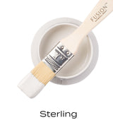 Open jar of Sterling Fusion Mineral Paint with brush coated in white acrylic paint.