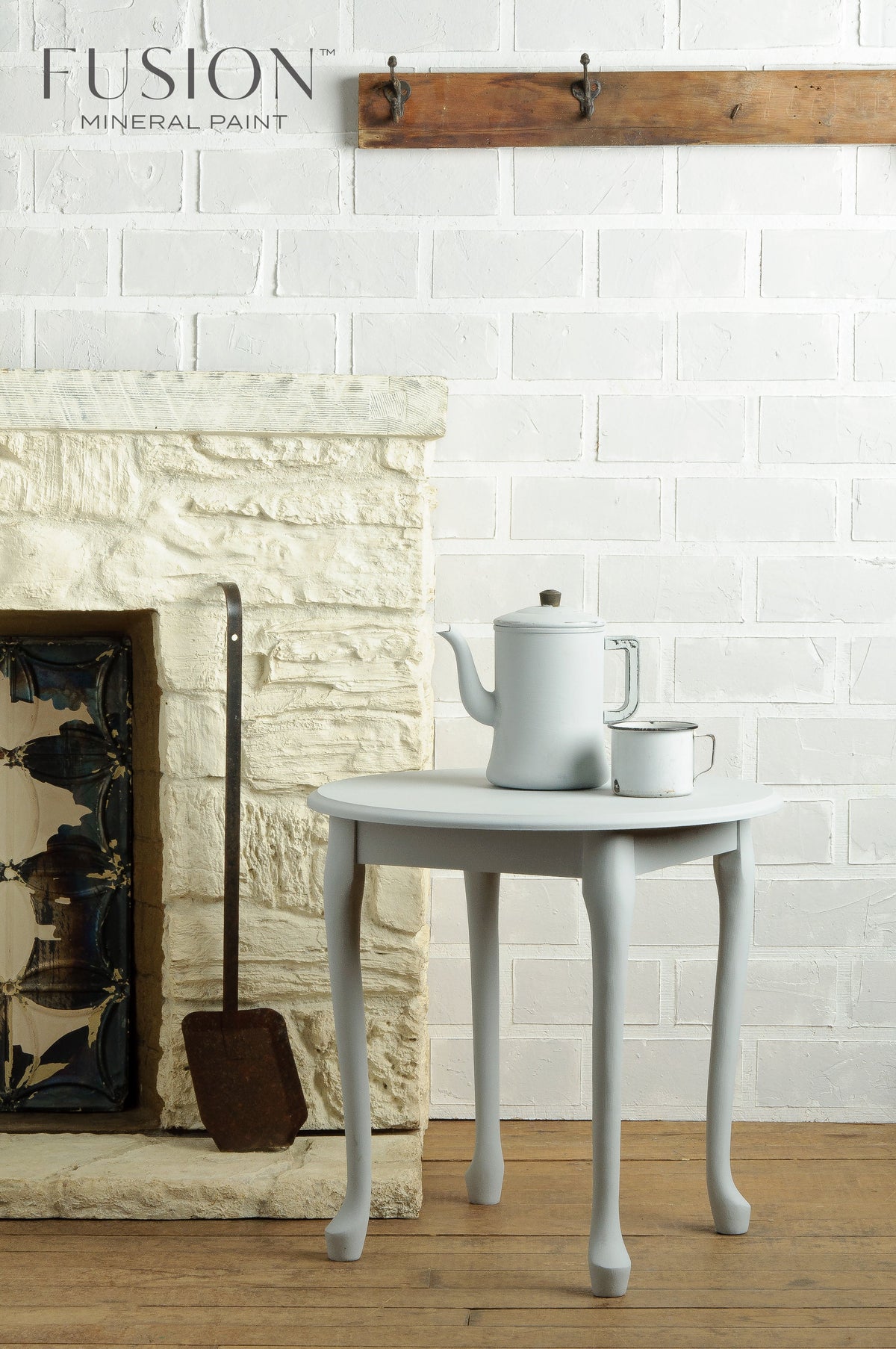 Small round table with teapot and cup beside a white brick wall in Sterling Fusion Mineral Paint matte finish.